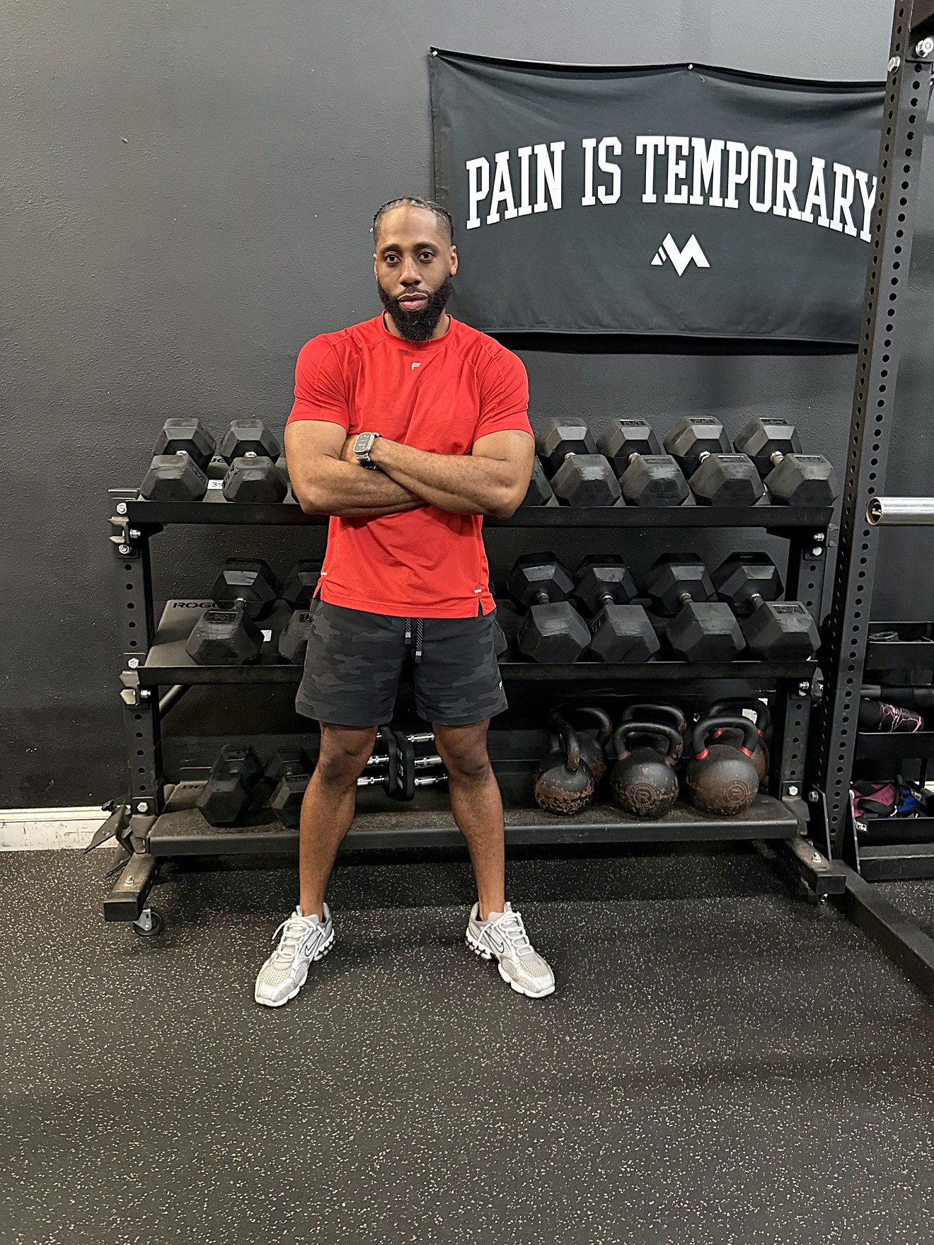 Faubert 'Coach Bert' Joseph, owner of Look Who's Fit, in front of the dumbbell rack